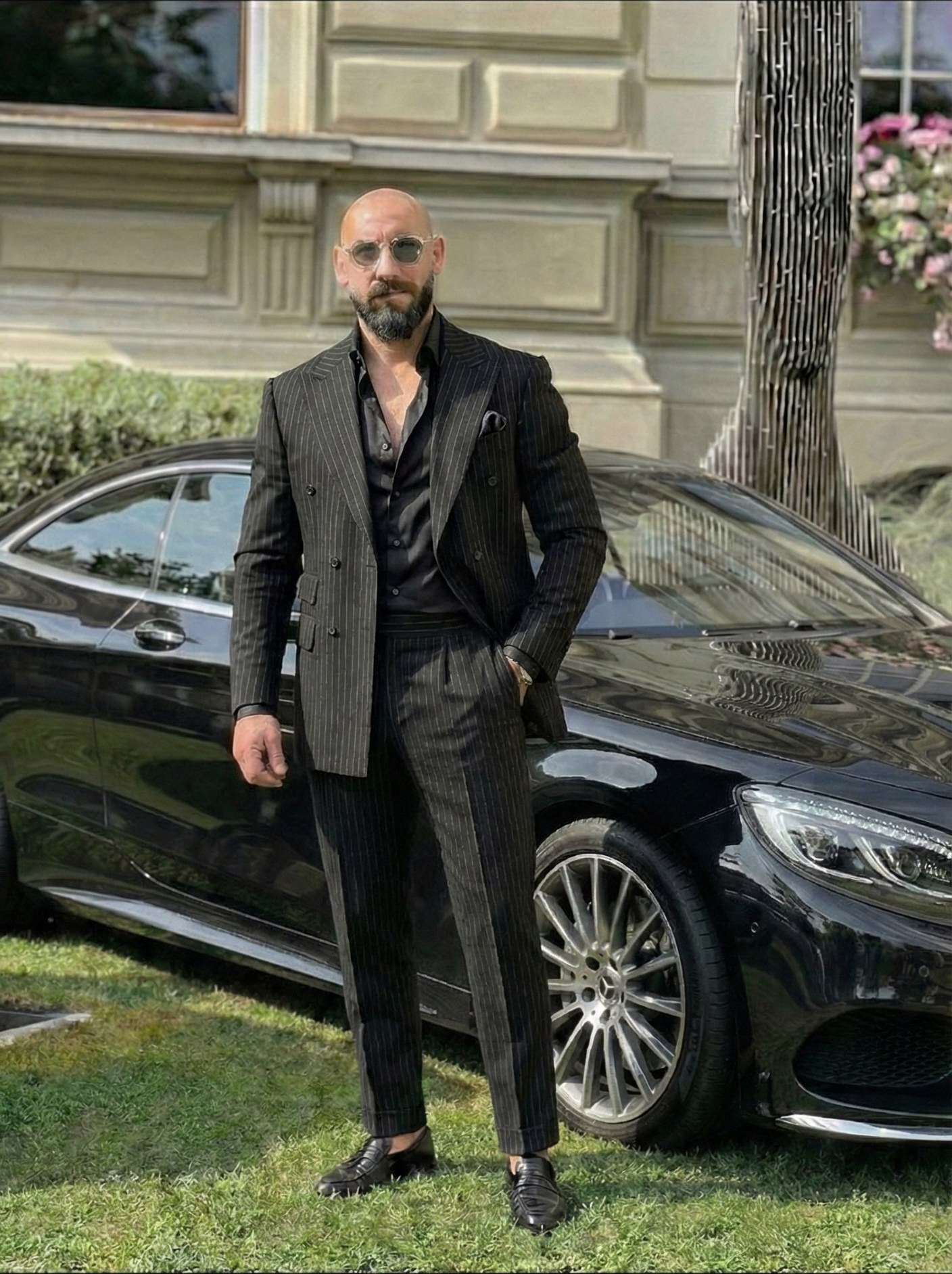 Founder of Blackline Direct standing beside his black coupé.